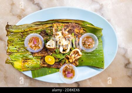 Gegrilltes Fischfilet mit Gewürzen auf Bananenblatt, beliebte malaysische Delikatesse. Stockfoto