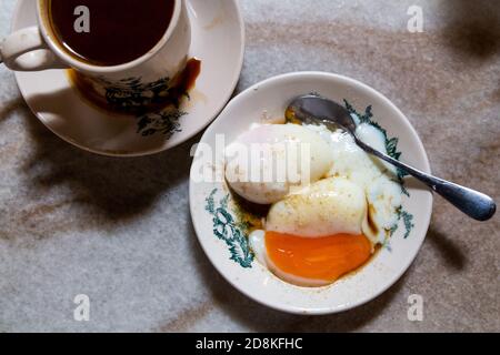 Halbgekochte Eier und Kaffee, beliebtes und nahrhaftes chinesisches Frühstück in Malaysia Stockfoto