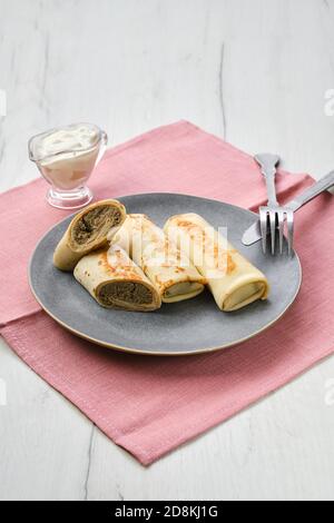 Teller mit dünnen Pfannkuchen gefüllt mit Hase Hackfleisch Stockfoto