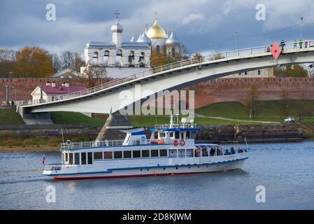 VELIKY NOWGOROD, RUSSLAND - 17. OKTOBER 2020: Das Lustschiff "Sadko" fährt unter der Fußgängerbrücke in der Nähe des Kremls von Veliky Nowgorod an einem Herbsttag Stockfoto