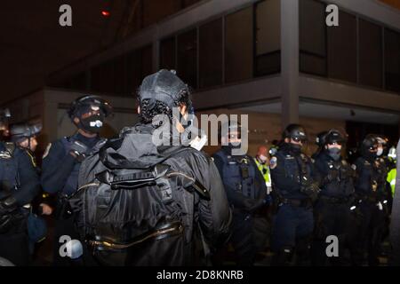 Washington, DC, USA, 30. Oktober 2020. Im Bild: Ein Protestler macht ein Video von Metropolitan (DC) Polizeibeamten, die in einer Schlange stehen, um sich mit friedlichen Demonstranten über die Ermordung von Karon Hylton-Brown letzte Woche zu stellen. Hylton-Brown wurde getötet, als die Polizei ihn jagte, während er mit einem Motorroller in ein fahrender Wagen fuhr und ihn tödlich verletzte. Wie Bürgermeister Muriel Bowser sagte, sind Verfolgungsjagden wegen Verkehrsverstößen in Washington streng verboten.mehrere Beschwerden wurden zuvor gegen den Offizier eingereicht, der ihn, Terrence Sutton, getroffen hat. Kredit: Allison C Bailey/Alamy Live Nachrichten Stockfoto