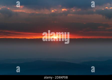 Erstaunlicher Sonnenaufgang mit dunklen Wolken vom Gipfel des Snezka Hügels Riesengebirge auf tschechisch - polnische Grenzen Stockfoto