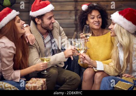 Gruppe von fröhlichen Menschen Toasting an weihnachten oder Neujahr Party in entspannter Atmosphäre zusammen. Weihnachten, Freunde, Toast, Spaß, Party-Konzept Stockfoto