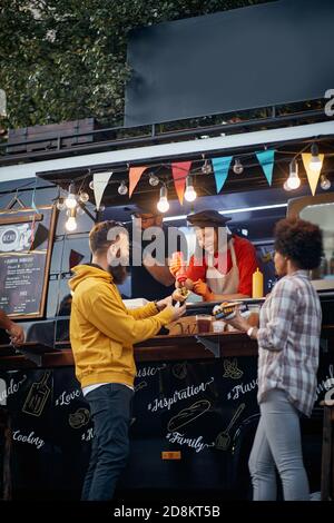 Gruppe von Freunden, die Spaß an Fast-Food-Mobile-Service Stockfoto