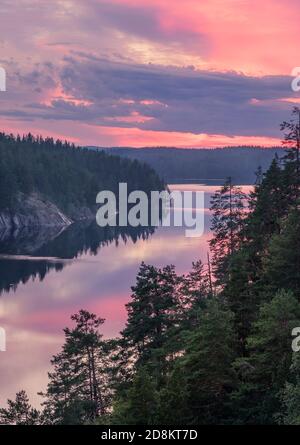 Malerische Wald- und Seenlandschaft mit ruhiger Stimmung und bunt Sonnenuntergang am Sommermorgen in Finnland Stockfoto