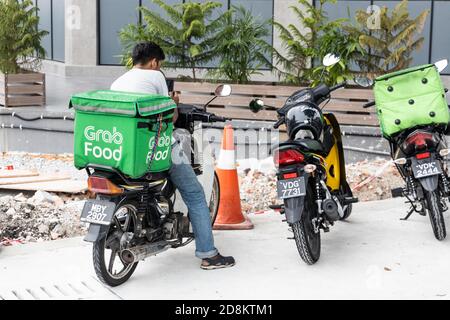 KUALA LUMPUR, MALAYSIA, 17. September 2019: Grabfood Riders warten vor den Restaurants auf den Auftrag zur Lieferung von Lebensmitteln. Grabfood ist ein Schnellster Stockfoto