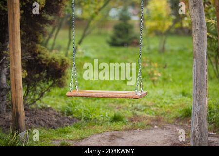 Eine alte hölzerne Schaukel, die in einem üppigen Hinterhof sitzt. Stockfoto