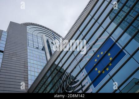 BRÜSSEL, BELGIEN - 21. Oktober 2020: Detail des Gebäudes des Europäischen parlaments, Fokus auf die EU-Flagge. Foto aufgenommen an einem bewölkten Tag Stockfoto