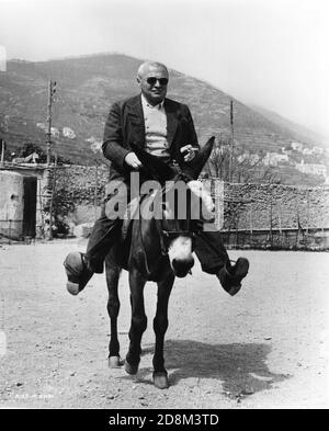 PETER LORRE reitet auf dem Esel Francisco an der Drehstelle In Ravello in Italien Dreharbeiten BEAT THE DEVIL 1953 Regisseur JOHN HUSTON Roman Claud Cockburn Drehbuch Truman Capote und John Huston UK - Italien - USA Koproduktion Romulus Films / Sehr Geehrter Film / Santana Pictures Corporation Stockfoto