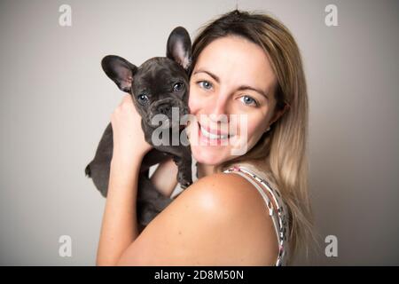 Schöne Frau mit französisch Bulldogge über weiß Stockfoto