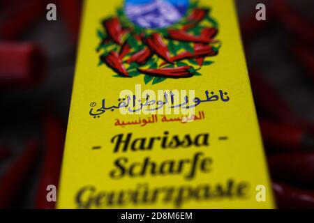 Viersen, Deutschland - 9. Oktober. 2020: Blick auf gelbes Päckchen tunesische Harissa Gewürzpaste Tube mit rotem Chilischuß Stockfoto