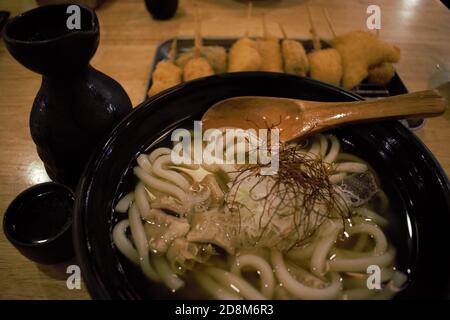 Schüssel mit Udon-Nudeln mit japanischem Sake und Kushikatsu in Tokio, Honshu, Japan Stockfoto