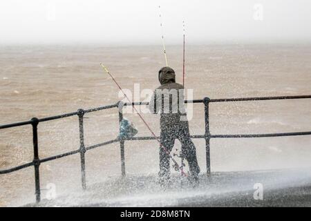 Fischer fischen auf rauer See in Crosby, Merseyside. Wetter in Großbritannien. Oktober 2020. Angeln im Sturm, Angler kämpfen, um auf ihre Ruten als starke Winde und starken regen Teig der Liverpool Estuary halten. Quelle: MediaWorldImages/AlamyLiveNews. Stockfoto