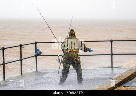 Fischer fischen auf rauer See in Crosby, Merseyside. Wetter in Großbritannien. Oktober 2020. Angeln im Sturm, Angler kämpfen, um auf ihre Ruten als starke Winde und starken regen Teig der Liverpool Estuary halten. Quelle: MediaWorldImages/AlamyLiveNews. Stockfoto