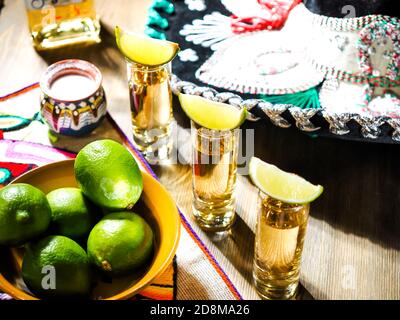 Drei Schüsse Tequila in hohen Schnapsgläsern mit Limette Keile oben Stockfoto