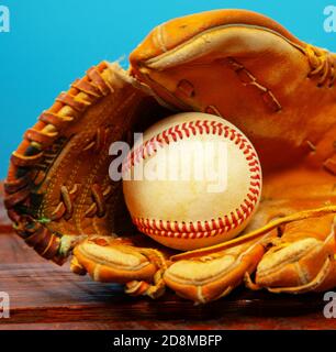 Ein Wetter-Baseballhandschuh aus Leder mit einem Baseball im Handschuh. Stockfoto