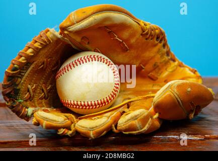 Ein Wetter-Baseballhandschuh aus Leder mit einem Baseball im Handschuh. Stockfoto