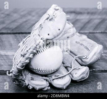 Ein Wetter-Baseballhandschuh aus Leder mit einem Baseball im Handschuh. Stockfoto