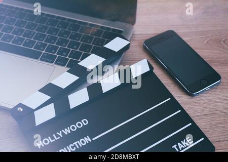 Movie Clapper Laptop und Smartphone auf dem Holztisch Stockfoto