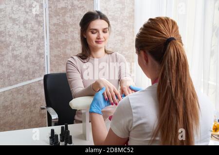 Oung Frau tut Maniküre im Salon. Schönheitskonzept. Stockfoto