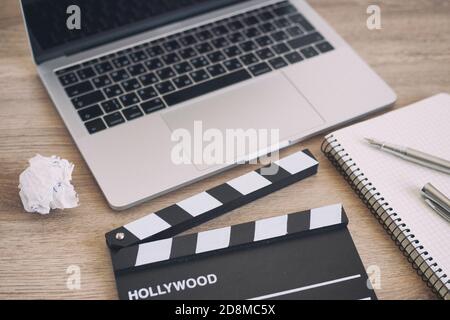 Videobearbeitung, Movie Clapper Laptop und Bleistift Notizblock auf dem Holz Tabellenansicht von oben Stockfoto