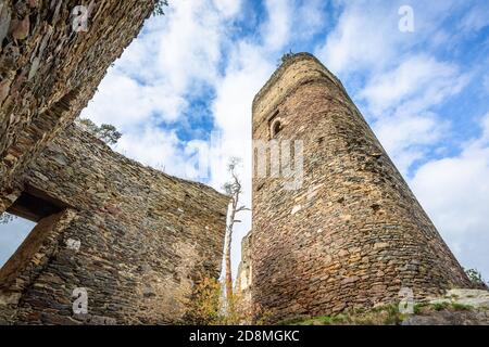 Gutstejn / Tschechische Republik - Oktober 10 2020: Blick von unten auf einen hohen Steinturm und eine Mauer, ein Teil der Ruine der mittelalterlichen gotischen Burg. Stockfoto