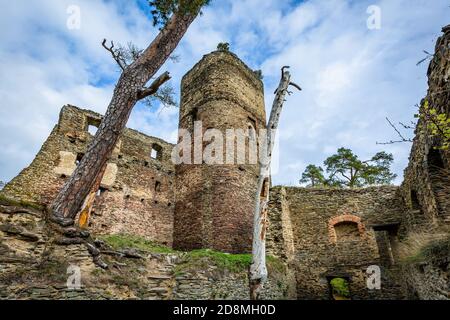 Gutstejn / Tschechische Republik - Oktober 10 2020: Blick auf einen steinernen Turm und eine Mauer, ein Teil der zerstörten mittelalterlichen gotischen Burg. Herbsttag mit blauem Himmel. Stockfoto