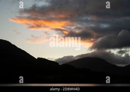 Atemberaubendes Landschaftsbild bei Sonnenaufgang mit Blick über Loweswater im See Bezirk in Richtung Low Fell und Grasmere mit bunten Himmel brechen Auf dem Berg Stockfoto