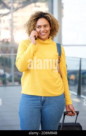 Porträt einer glücklichen Reisefrau, die auf dem Handy spricht Stockfoto