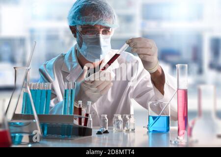 Wissenschaftler im Labor, der eine Probe in einem Reagenzglas betrachtet. Horizontale Zusammensetzung. Vorderansicht. Stockfoto