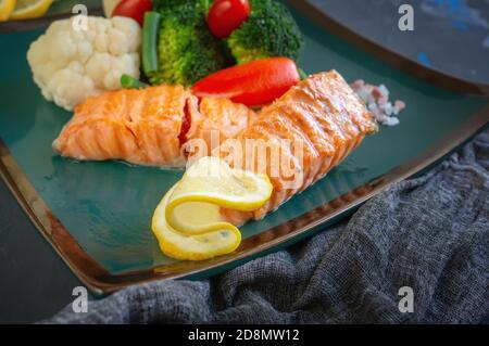 Gegrilltes Lachssteak mit Kräutern und Gemüse Rosenkohl und Blumenkohl. Diätgericht der mediterranen Ernährung Stockfoto