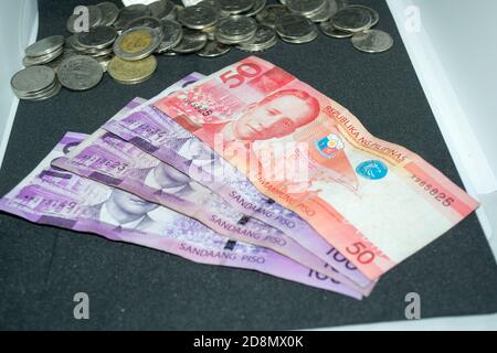 100 und 50 philippinische Peso-Scheine und philippinische Peso-Münzen Stockfoto