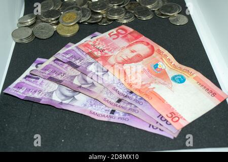 100 und 50 philippinische Peso-Scheine und philippinische Peso-Münzen Stockfoto