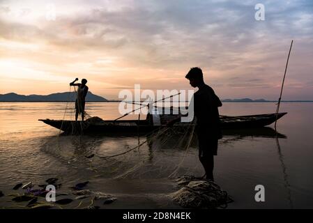 Guwahati, Assam, Indien. Oktober 2020. Fischer, die ihre Fischernetze auf dem Fluss Brahmaputra vorbereiten und reinigen, bei Sonnenuntergang, in Guwahati. Quelle: David Talukdar/ZUMA Wire/Alamy Live News Stockfoto