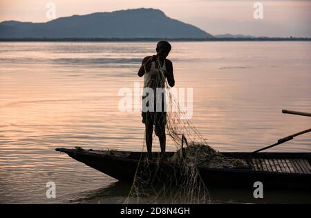 Guwahati, Assam, Indien. Oktober 2020. Fischer, die ihre Fischernetze auf dem Fluss Brahmaputra vorbereiten und reinigen, bei Sonnenuntergang, in Guwahati. Quelle: David Talukdar/ZUMA Wire/Alamy Live News Stockfoto