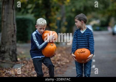 London, Großbritannien. Oktober 2020. Machen Sie sich bereit für die Halloween-Nacht. Oktober 2020. Wimbledon, Southwest London, UK zwei Jungs (Model Released) tragen Kürbisse vor Halloween nach Hause, Southwest London, England, UK Credit: Jeff Gilbert/Alamy Live News Stockfoto