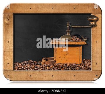 Alte manuelle Kaffeemühle aus Metall und Holz mit gerösteten Kaffeebohnen in einer Tafel mit Kopierraum, isoliert auf weißem Hintergrund. Stockfoto