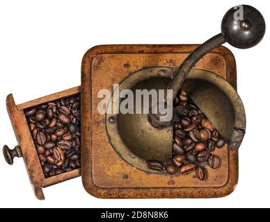 Alte manuelle Kaffeemühle aus Metall und Holz mit gerösteten Kaffeebohnen isoliert auf weißem Hintergrund. Draufsicht. Italien. Stockfoto