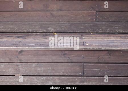 Nahaufnahme einer Veranda-Wand aus braunen und grauen Holzplanken mit Relief als Hintergrund für ein Herbstdekor oder eine Plakatwand. Stockfoto