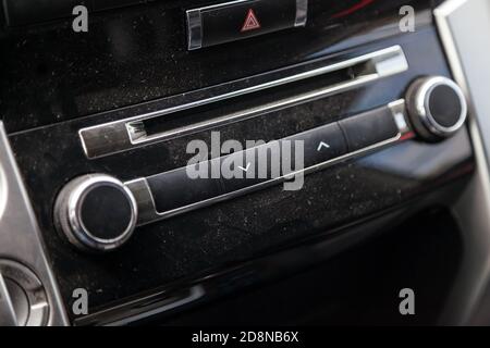 Nahaufnahme einer schwarzen Mittelkonsole aus Kunststoff mit einer Stereoanlage mit Radio-Tasten und Kippschaltern unter dem Not-aus-Schalter. Stockfoto