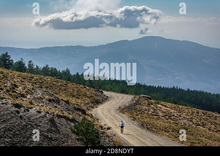 Mann übt Sport mit dem Fahrrad in den Gipfeln der Sierra Nevada, Granada. Stockfoto