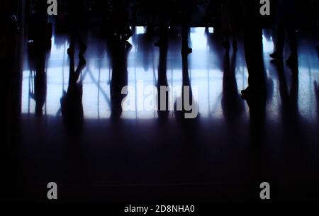 Eine Menge Leute, in Silhouette, warten in der Schlange am Flughafen Stockfoto