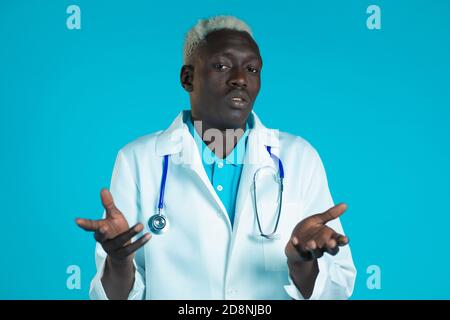 Porträt von unsicher afrikanischen Arzt in professionellen medizinischen weißen Mantel zuckt seine Arme, macht Geste von Ich weiß nicht, Pflege. Körpersprache. DOC man. Stockfoto