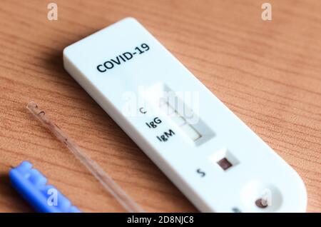 Nahaufnahme der Covid-19 IgG/IgM-Schnelltestkassette, die auf eine positive Infektion hinweist. Stockfoto