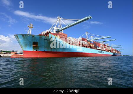 Miami, Florida - 30. Oktober 2020 - am sonnigen Herbstnachmittag lädt das Containerschiff Frachtcontainer unter Portalkranen in Port Miami. Stockfoto