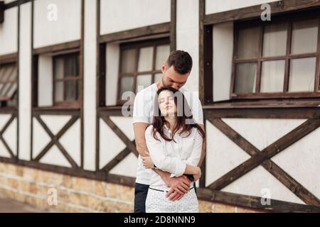 Glückliche junge Mann und Frau mit Spaß im Freien an einem warmen Sommertag. Paar umarmt in der Nähe Pferd rancho Stockfoto