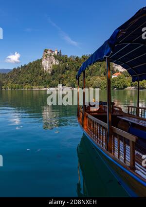 Ein Bild von einer Gondel des Bleder Sees, genannt "Pletna", mit Blick auf die Burg von Bled. Stockfoto