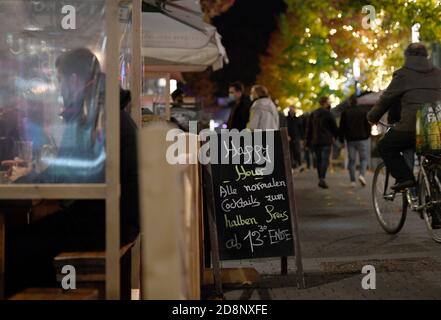 Bochum, Deutschland. Oktober 2020. Auf einem Schild im Ausgehviertel Bermuda3eck wirbt ein Restaurant mit der Happy Hour. Die Bundes- und Landesregierungen haben sich für eine teilweise Sperrung ab kommenden Montag entschieden. Dazu gehört auch die Schließung des Restaurants. Quelle: Caroline Seidel/dpa/Alamy Live News Stockfoto