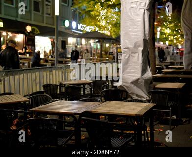 Bochum, Deutschland. Oktober 2020. Stühle und Tische befinden sich im Bermuda3eck-Nachtleben außerhalb eines bereits geschlossenen Restaurants. Bundes- und Landesregierungen haben eine teilweise Sperrung ab kommenden Montag beschlossen. Dazu gehört auch die Schließung des Restaurants. Quelle: Caroline Seidel/dpa/Alamy Live News Stockfoto