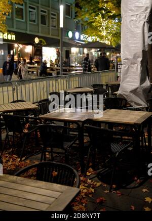 Bochum, Deutschland. Oktober 2020. Stühle und Tische befinden sich im Bermuda3eck-Nachtleben außerhalb eines bereits geschlossenen Restaurants. Bundes- und Landesregierungen haben eine teilweise Sperrung ab kommenden Montag beschlossen. Dazu gehört auch die Schließung des Restaurants. Quelle: Caroline Seidel/dpa/Alamy Live News Stockfoto